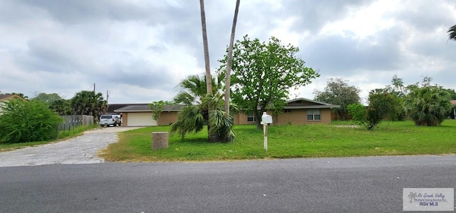 single story home with an attached garage, a front yard, and aphalt driveway
