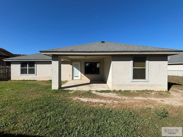 rear view of property featuring a lawn