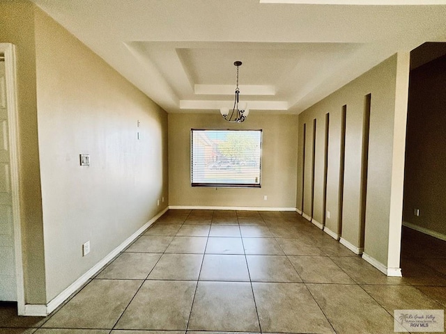 unfurnished dining area with a tray ceiling and tile patterned floors