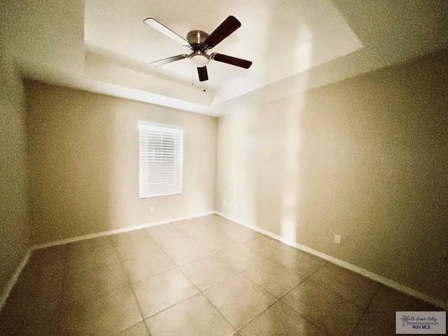 unfurnished room featuring a tray ceiling and ceiling fan