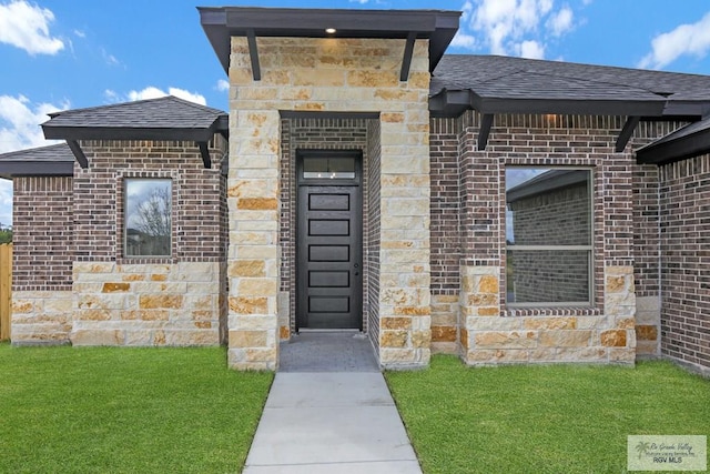 entrance to property with a lawn