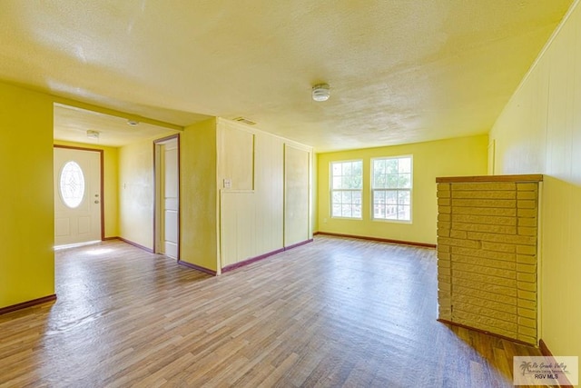 22916 N Oscar St, Harlingen, TX 78552 - empty room with wood finished floors, a textured ceiling, and plenty of natural light