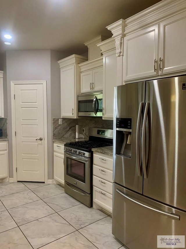 kitchen with tasteful backsplash, light stone countertops, white cabinetry, and appliances with stainless steel finishes