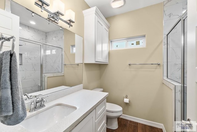 bathroom featuring vanity, toilet, wood-type flooring, and a shower with door