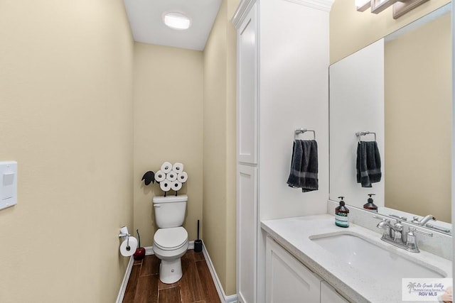 bathroom featuring vanity, hardwood / wood-style flooring, and toilet