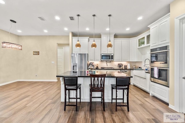 kitchen featuring a center island, stainless steel appliances, and hanging light fixtures