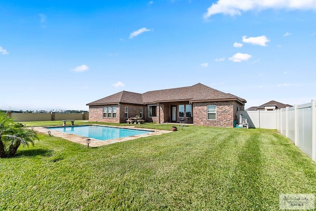 view of swimming pool with a yard