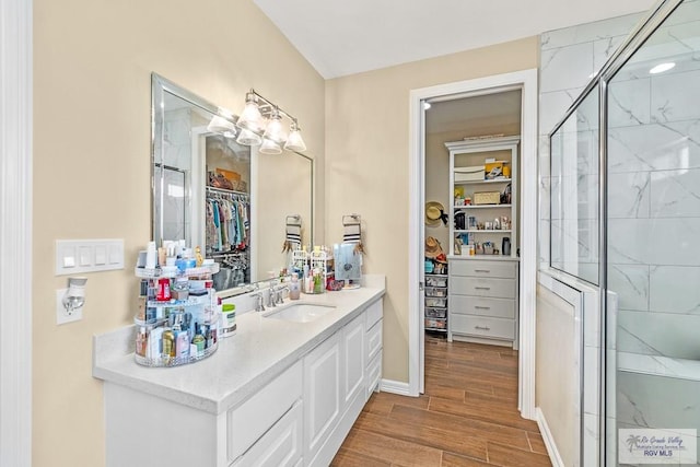 bathroom featuring a shower with door, vanity, and wood-type flooring