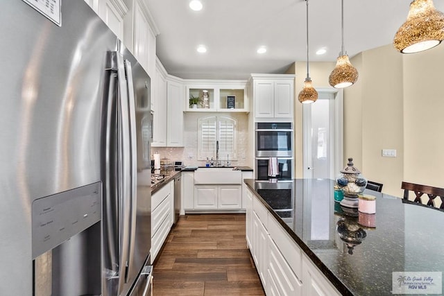 kitchen with white cabinets, sink, stainless steel appliances, and hanging light fixtures