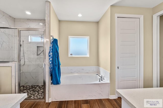 bathroom featuring vanity, hardwood / wood-style flooring, and separate shower and tub