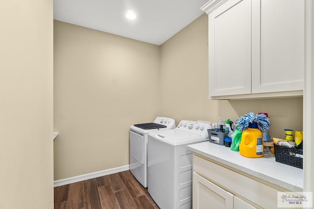 clothes washing area with cabinets, washer and clothes dryer, and dark wood-type flooring