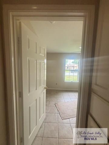 1022 Madison Ave, Harlingen, TX 78550 - hallway with light tile patterned floors and baseboards