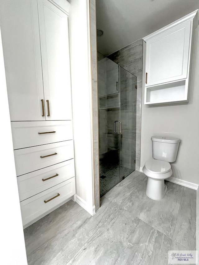 bathroom with toilet and a shower with shower door