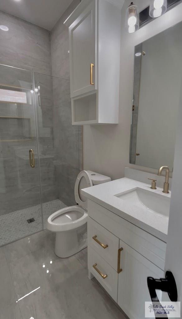 bathroom with vanity, a shower with shower door, and toilet