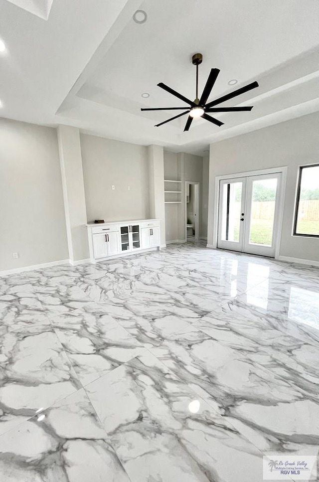 unfurnished living room featuring ceiling fan and french doors