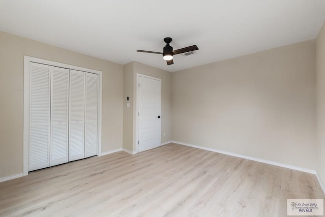 unfurnished bedroom featuring a closet, light hardwood / wood-style floors, and ceiling fan