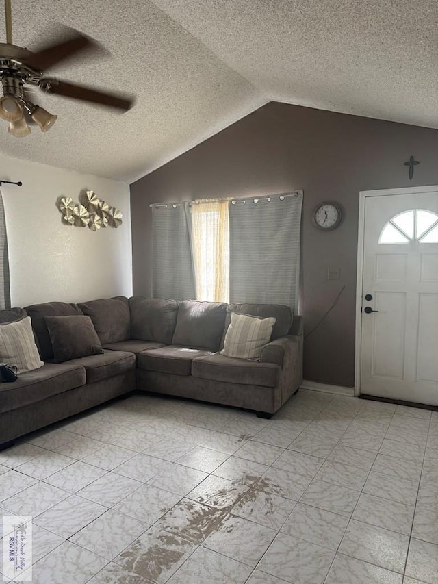 living room with lofted ceiling, a textured ceiling, marble finish floor, and ceiling fan