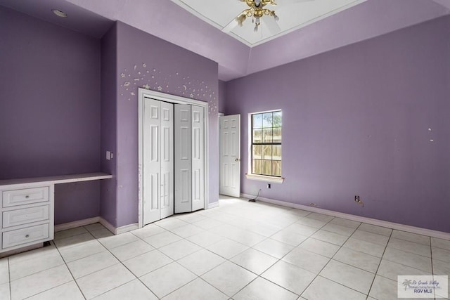 2107 S Victoria Rd, Donna, TX 78537 - unfurnished bedroom featuring a closet, tile patterned floors, built in desk, and a high ceiling