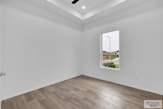 empty room featuring light wood finished floors, baseboards, a ceiling fan, and recessed lighting