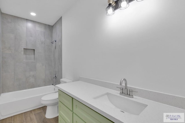 full bathroom featuring toilet, recessed lighting, wood finished floors, vanity, and  shower combination