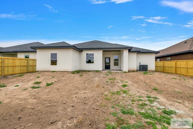 rear view of house featuring a fenced backyard, cooling unit, and stucco siding