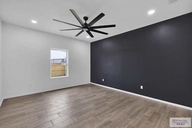 empty room with light wood-style floors, ceiling fan, and baseboards