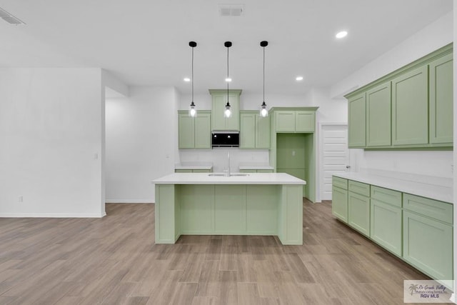 kitchen featuring visible vents, light countertops, light wood-type flooring, and decorative light fixtures