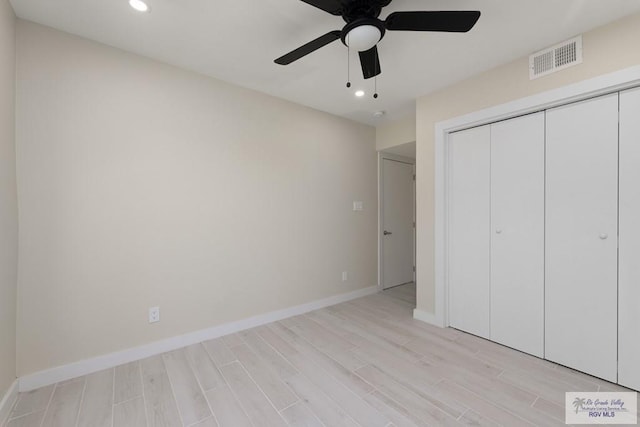 unfurnished bedroom with light wood finished floors, baseboards, visible vents, and a closet