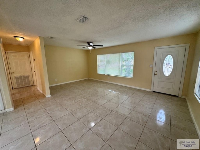 1017 E Austin Ave, Harlingen, TX 78550 - foyer entrance featuring light tile patterned floors, healthy amount of natural light, a ceiling fan, and a textured ceiling
