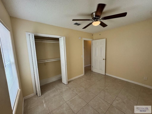 1017 E Austin Ave, Harlingen, TX 78550 - unfurnished bedroom with light tile patterned floors, a textured ceiling, a closet, and ceiling fan