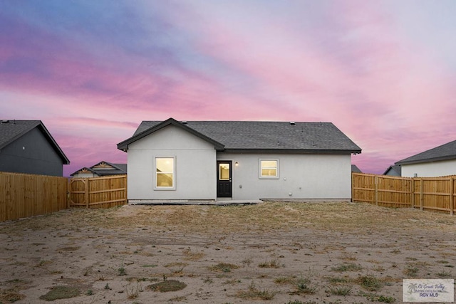 view of back house at dusk