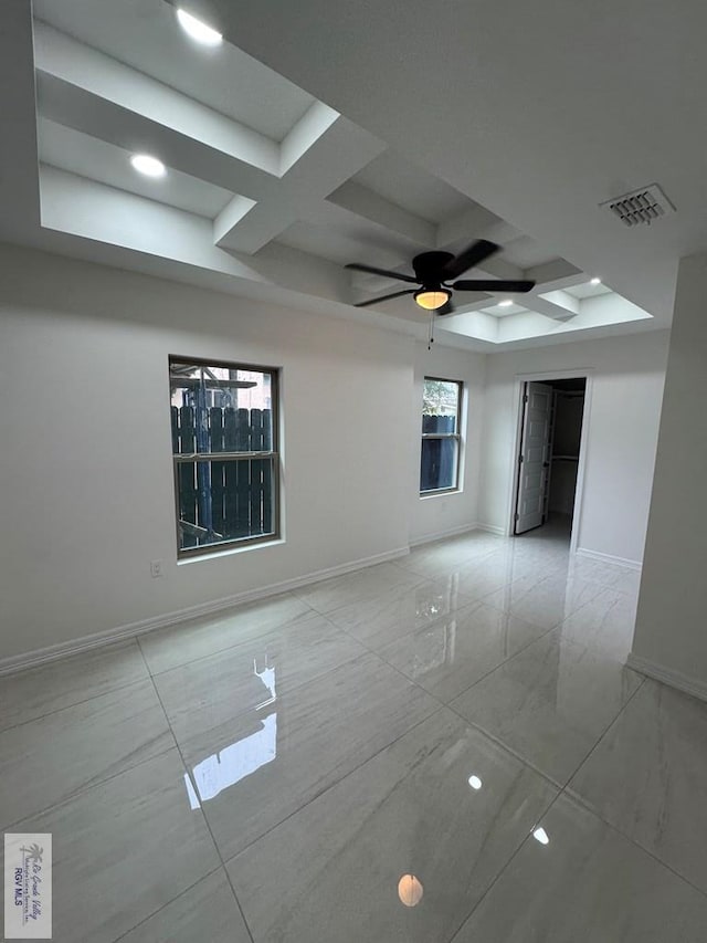 spare room featuring coffered ceiling, beam ceiling, and ceiling fan