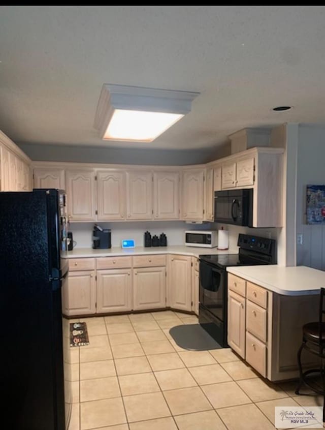 kitchen featuring black appliances, light tile patterned floors, and kitchen peninsula