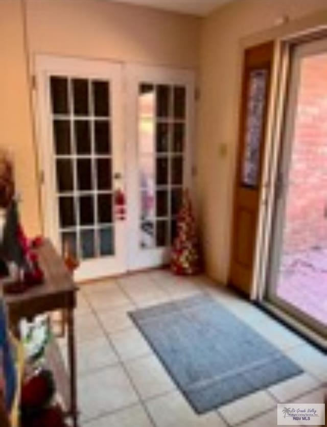 entryway with tile patterned floors and french doors