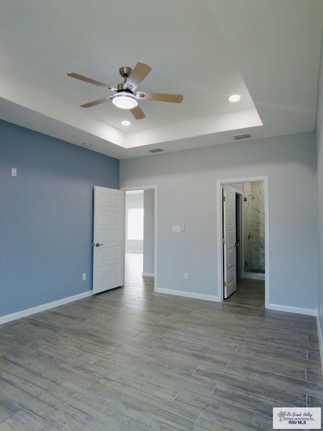 unfurnished room featuring ceiling fan and a raised ceiling