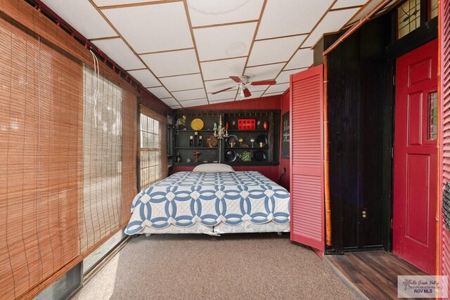 unfurnished bedroom featuring wood walls, dark hardwood / wood-style flooring, and lofted ceiling