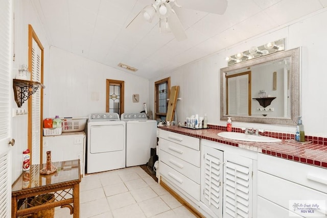 bathroom with ceiling fan, sink, tile patterned floors, vaulted ceiling, and washer and dryer