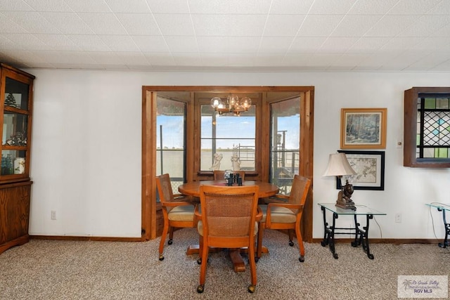 carpeted dining space with a notable chandelier