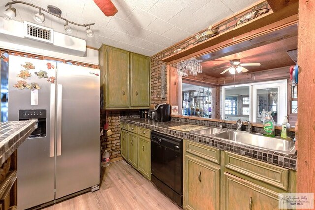 kitchen featuring sink, black dishwasher, green cabinets, and stainless steel refrigerator with ice dispenser