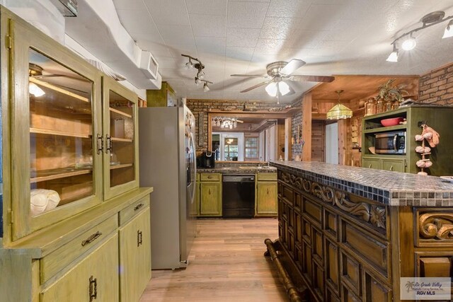 kitchen featuring kitchen peninsula, appliances with stainless steel finishes, light wood-type flooring, ceiling fan, and decorative light fixtures