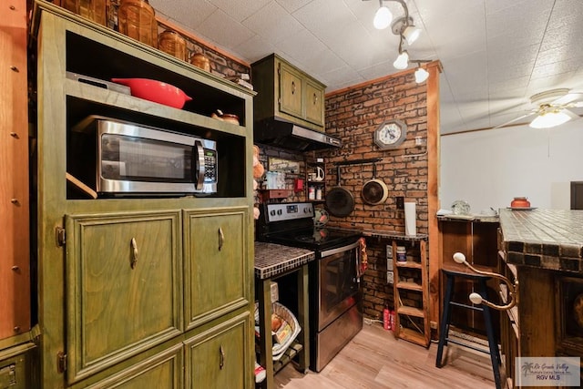 kitchen with tile countertops, stainless steel appliances, light hardwood / wood-style flooring, and green cabinetry