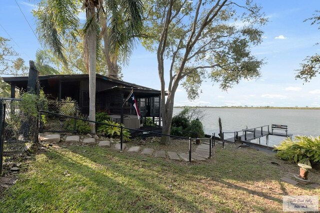 view of yard featuring a water view and a dock