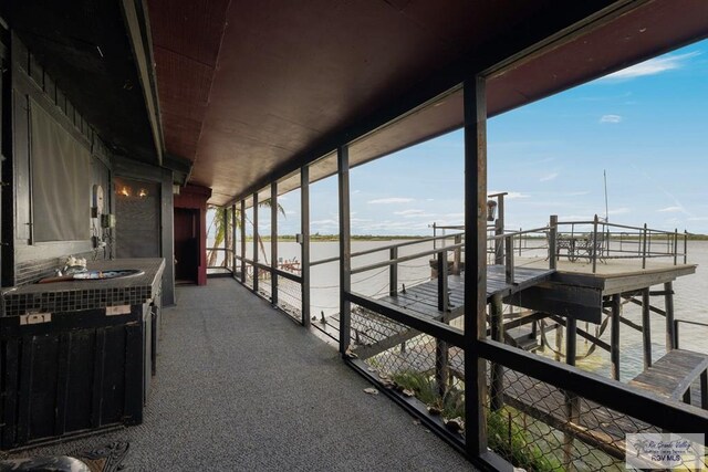 sunroom / solarium featuring a water view