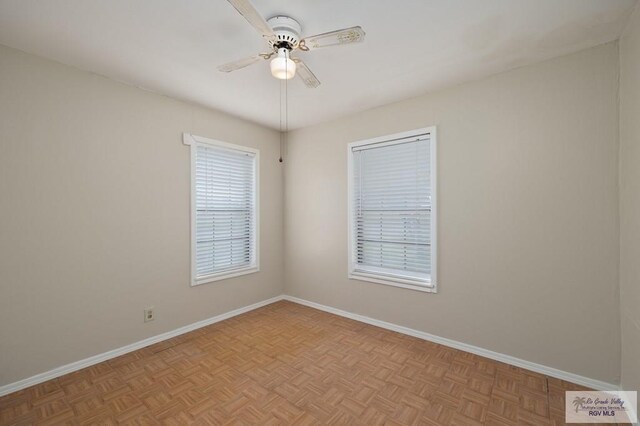 spare room with ceiling fan and light parquet floors