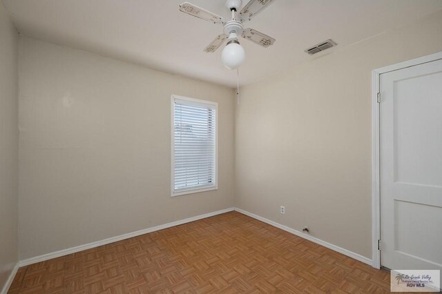 empty room with light parquet flooring and ceiling fan