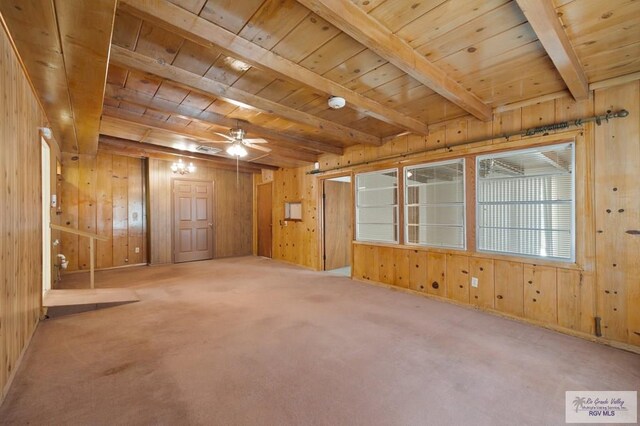 empty room with wood walls, wooden ceiling, carpet flooring, ceiling fan, and beamed ceiling