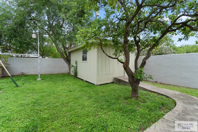 view of yard featuring a storage shed, an outbuilding, and a fenced backyard