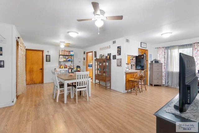 dining space with light wood finished floors, visible vents, ceiling fan, and baseboards