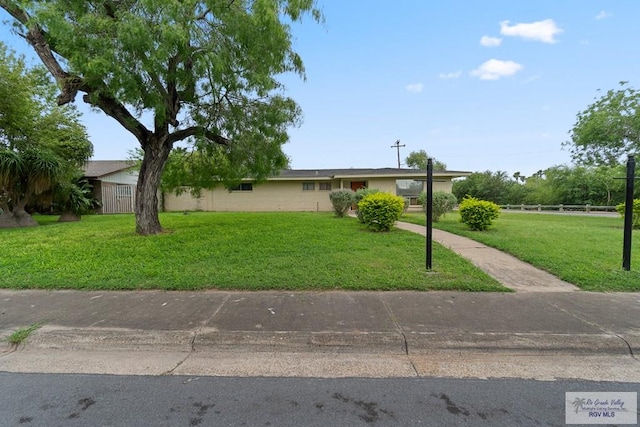 view of front of property with a front yard and fence