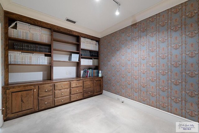 unfurnished room featuring rail lighting, ornamental molding, and light carpet